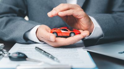 homme signe contrat assurance auto